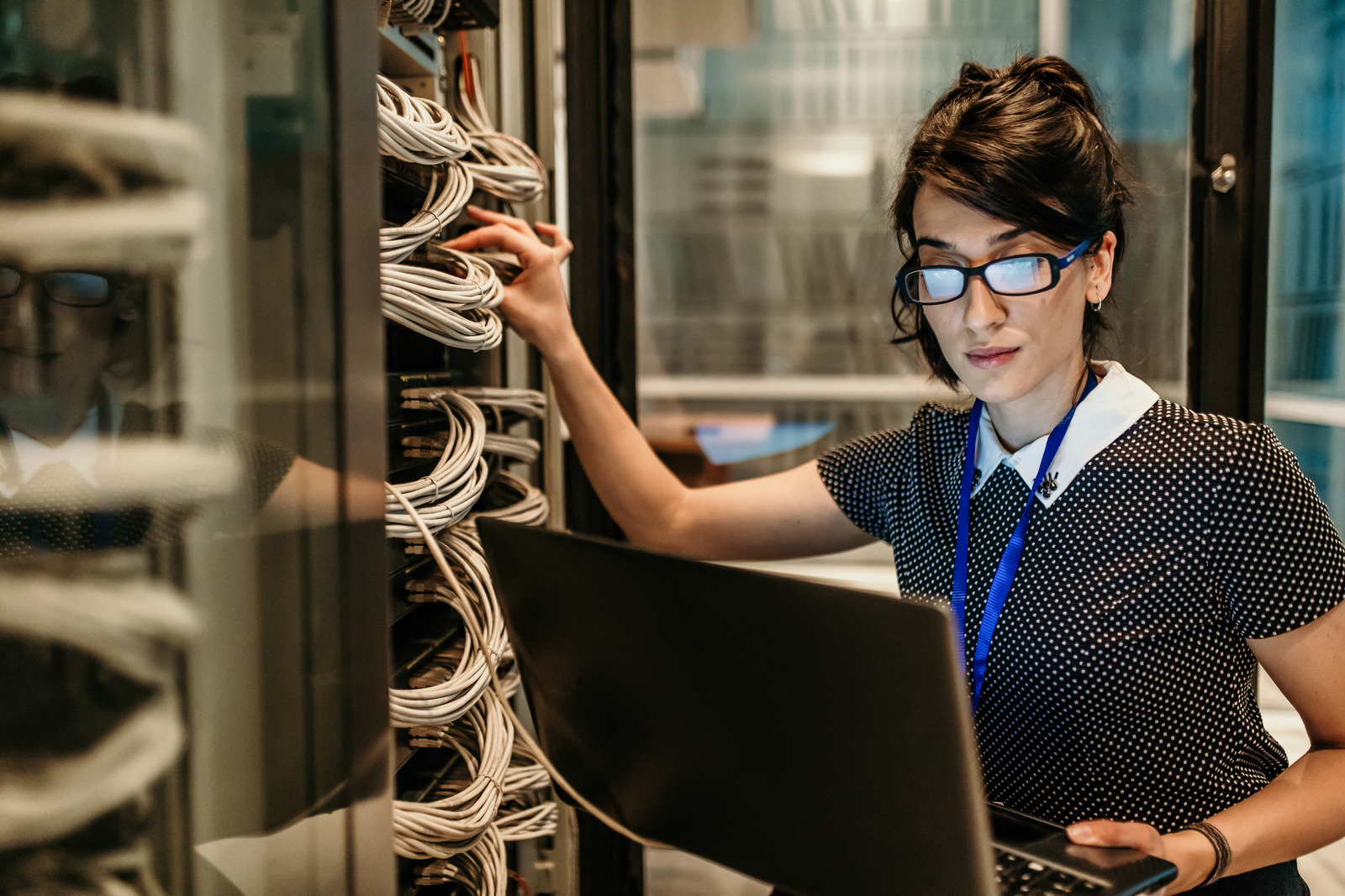 Support technician reviewing network connections inside a rack
